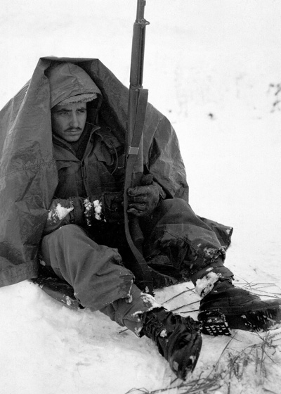 ■ 여주 지역의 전투가 잠시 소강상태일 때 제19보병연대 소속 병사가 에는 바람과 추위로부터 몸을 보호하기 위해 판초를 두르고 있다. 1951년. ⓒ Cpl. E. Watson / U.S. Department of Defense.
